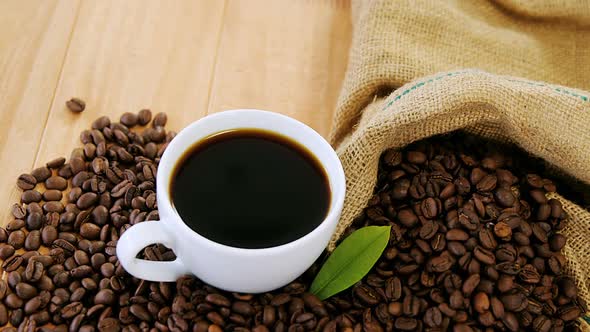 Coffee cup with coffee beans and leaf alt