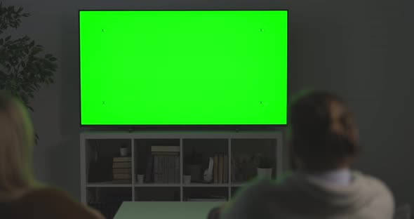 Family Looking at Green Screen TV