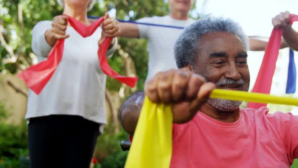 Senior friends exercising with resistance band 4k alt