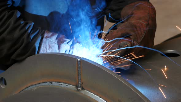 Crop Worker Welding Metal Tube. Welder Working In His Workshop Makes A Weld On The Dark Metal