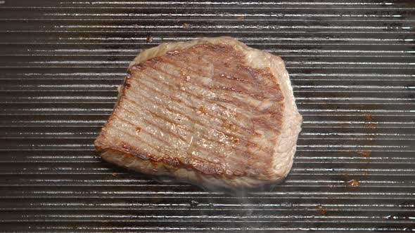 Tasty beef steak fries on a grill