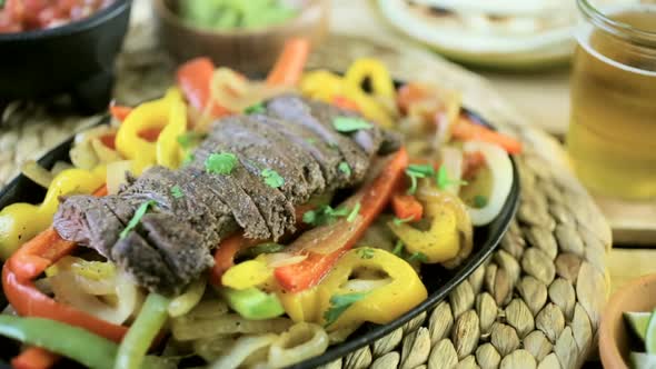Outdoor cooking. Steak fajitas with bell peppers and yellow onion on a cast iron fajita skillet. alt