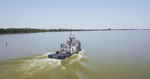 Industrial boat sailing up Jacui River, Brazil. Aerial tracking pan shot alt