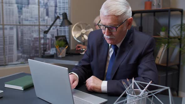 Elderly Man Boss Working in Office Room Rubbing His Chin Pondering Solution Doubting Question alt
