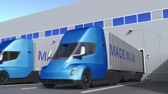 Trailer Trucks with MADE IN UK Text Being Loaded or Unloaded alt