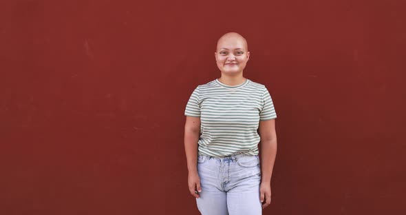 Bald girl posing and smiling in front of camera - Real people, diversity and female power alt