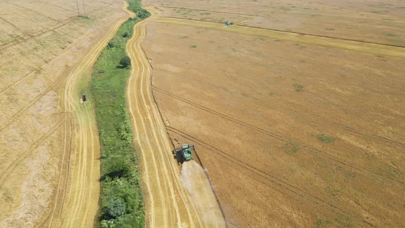 Aerial View of Lorry Cargo Truck Driving on Dirt Road Between Agricultural Wheat Fields alt