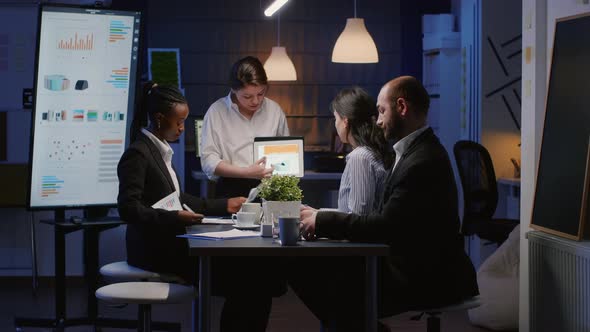 Diverse Multiethnic Businesspeople Analyzing Management Graphs Using Tablet alt