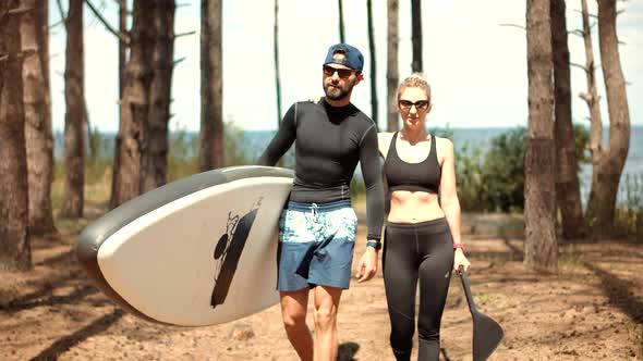 Couple After Swim Surfing Boat Fitness Workout With Oar.Travel SUP Water Tourism Holiday Vacation. alt