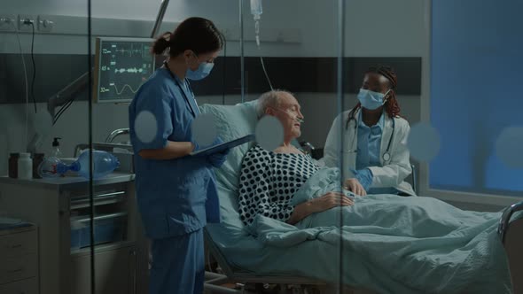 Multi Ethnic Medical Staff Talking About Treating Patient alt