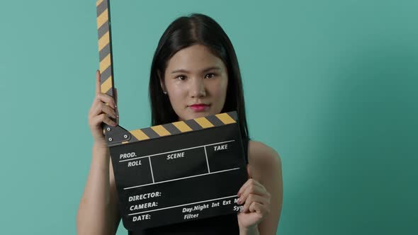 Movie slate and little sexy cute asian girl. Woman holding and clapping movie clapperboard