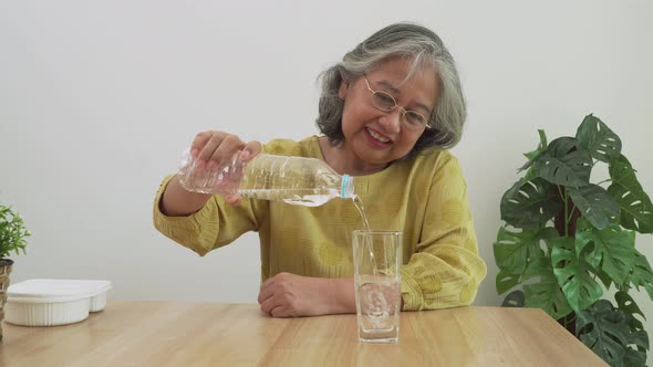 Happy Asian elderly women are drinking Water From Bottle for good health. Good health, lifestyle. alt