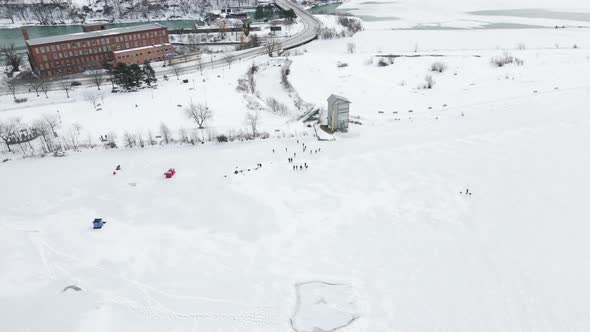 Overhead of multiple kids and adults ice skating on frozen Martindale Pond, Port Dalhousie, Ontario alt
