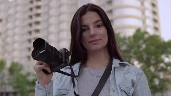 Attractive Professional Photographer Woman with Equipment Looking at Camera