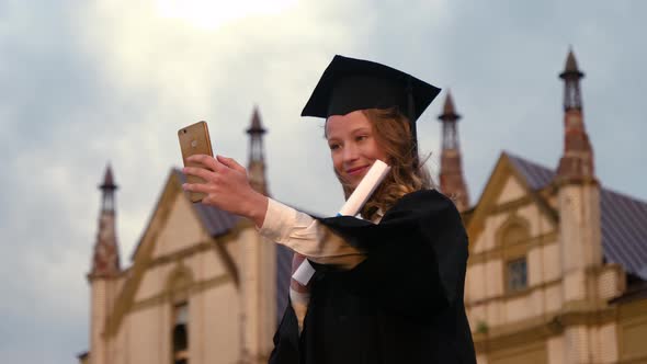 Beautiful Attractive Graduated Woman in Cap and Gown Smile and Take a Selfie Feeling so Proud alt
