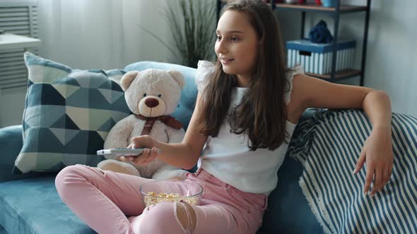 Happy Kid Watching Funny Comedy on TV Eating Popcorn and Laughing Having Fun Alone alt
