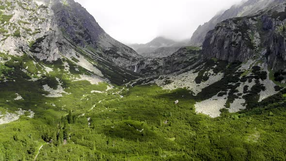 AERIAL: Descending into Green Forest Valley with Two Mountains in High Tatras Region in Slovakia alt