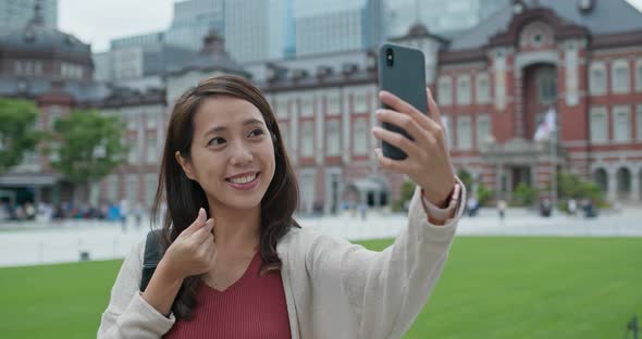 Woman travel in Tokyo and use of mobile phone at Tokyo station alt