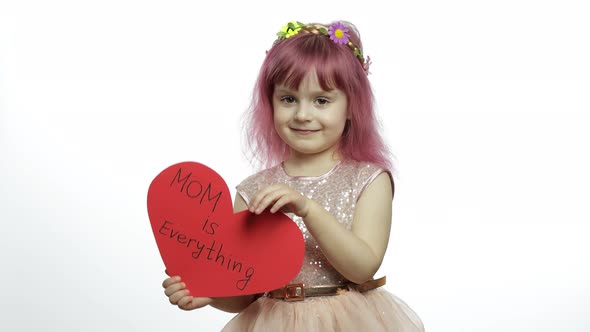 Child Girl Princess Holds Red Paper Heart with Text About Mother. Mother's Day alt