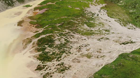 Broad Valley with Vegetation Lies Among Rocky Mountains alt
