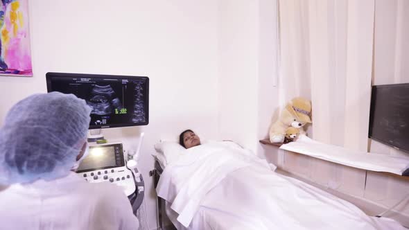 Indian Mother And Ultrasound Operator Viewing Her Baby alt