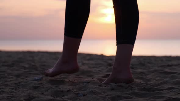 Close-up legs of a woman walking along the seashore