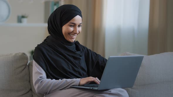 Smiling Arab Islamic Woman Muslim Young Girl in Hijab Freelancer Student Using Laptop Leaning on alt