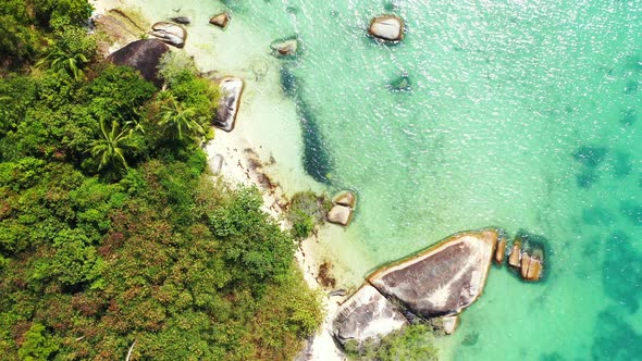 Natural overhead tourism shot of a white paradise beach and blue water background in 4K alt