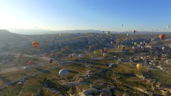 Aerial drone shot of hot air balloons soaring in the sky. Sunny morning in Cappadocia