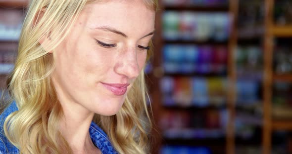 Smiling female staff standing in super market alt