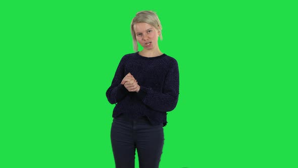 Blonde Girl with Creative Haircut Is Keeping Palm Together and Asking for Something on a Green alt