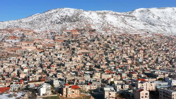 Hermon mountain ridge covered with snow during 2022 winter, with the town houses of Majd al Shams. alt