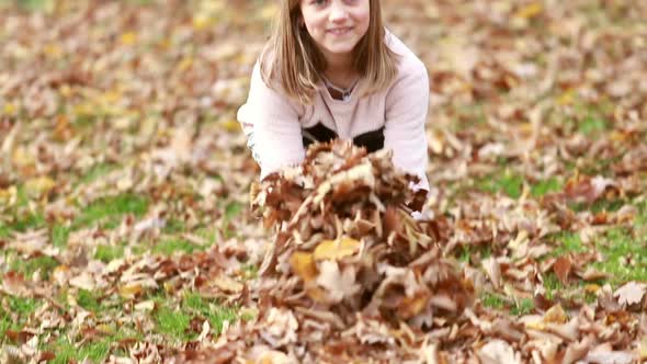 Lovely girl throwing leaves alt
