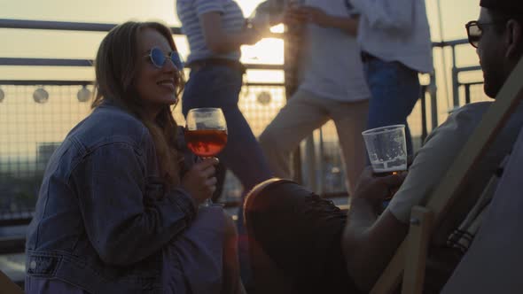 Young couple chilling together at the rooftop party. Shot with RED helium camera in 8K. alt