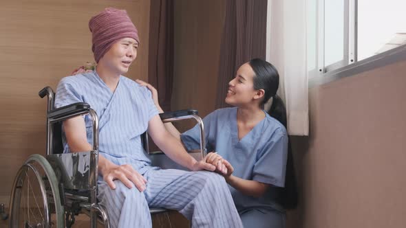 A female doctor with a wheelchair patient at window, recovering from illness. alt