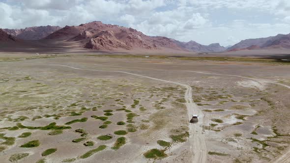 Aerial Over Off Road 4X4 Gravel Trail Path on Arid Colorful Desert Mountains