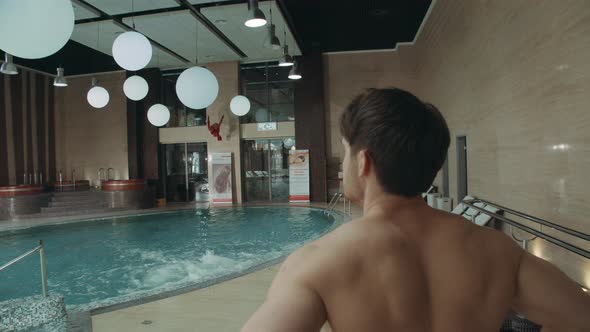 Handsome Man Entering Hotel Spa. Sporty Guy Looking Around in Spa Center. alt