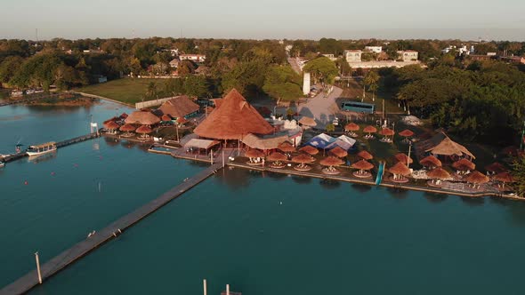 Sunset at Tropical Holiday with Piers and Huts in Summer at Lake Bacalar Mexico