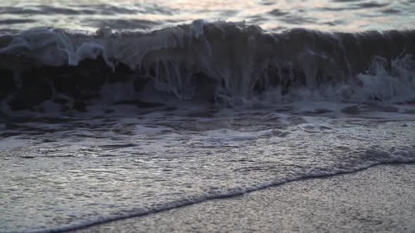 Stormy Sea Waves with White Foam is Rolling in Tubes Lapping on Pebble Beach
