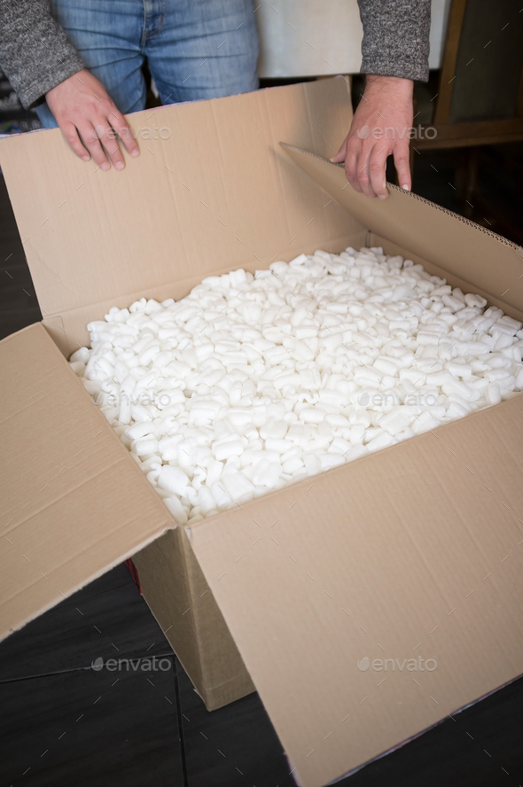 unpacking a box with a fragile item - Stock Photo - Images