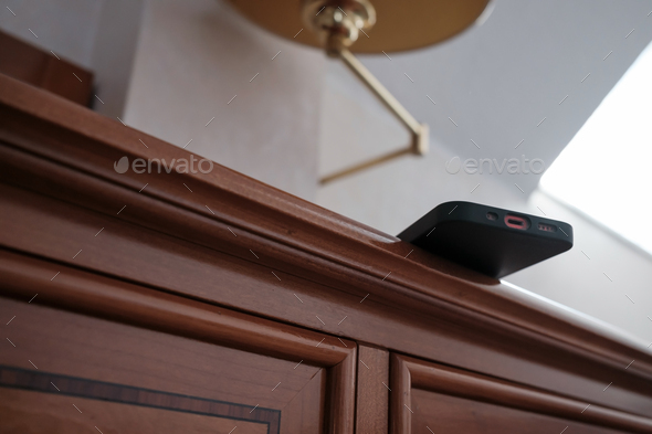 Smartphone is carelessly left on the edge of the dresser and may fall. Concept of careless attitude