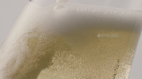Sparkling white wine bubbling pouring in goblet close up. Champagne foaming.