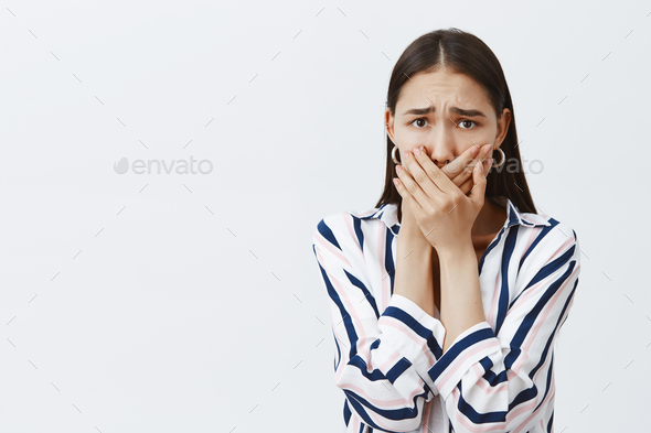 Woman being harassed afraid to tell anyone. Scared anxious girlfriend in striped blouse and trendy e