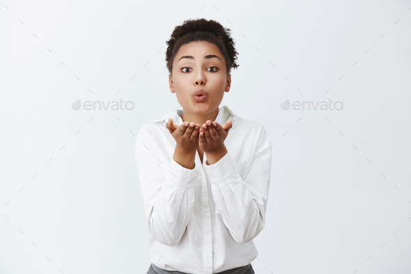 Woman gazing at mirror every morning, blowing herself kiss to boost confidence and wish good day. Po