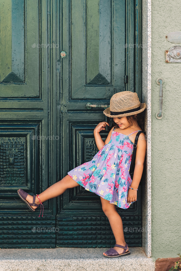Little girl poses funny in front of the green door