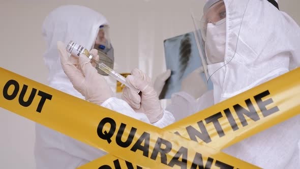 Doctors in Protective Suit Checking Chest X-ray Film, Test Sample of the Vaccine alt