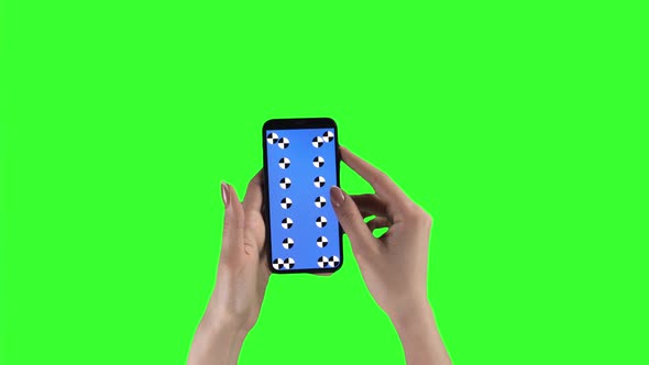 Woman Holds Smartphone By Two Hands and Sliding Pages Against Chroma Key Background alt
