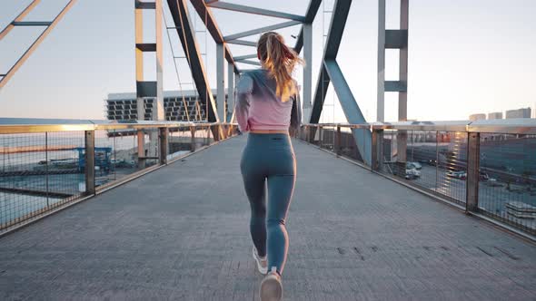 Back View Slim Young Lady Running Across City Port Bridge alt
