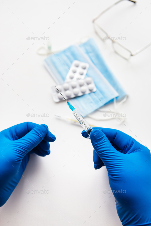 A doctor\'s hand in blue gloves prepares for vaccination. Coronavirus, covid-19 vaccination.