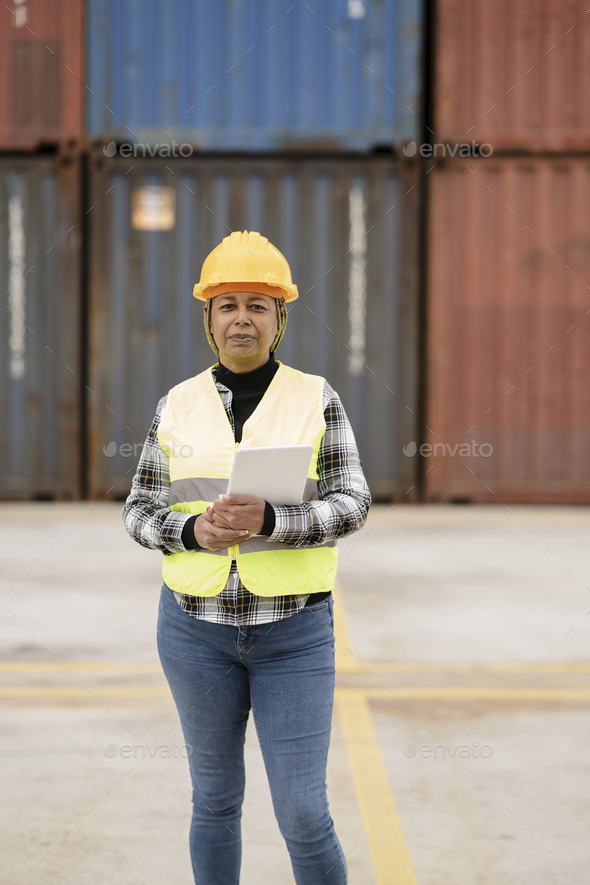 African American elderly woman worker in industrial port in the background - production manager -